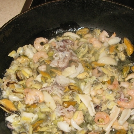 1. Этап. Рис с морепродуктами в мультиварке: На горячую сковородку налейте немного растительного масла и выложите морепродукты. Обжарьте их до полуготовности и уберите в сторону.