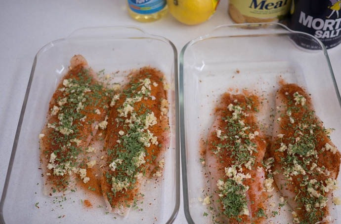 1. Этап. Тиляпия в кляре: Добавьте давленный чеснок, полейте лимонным соком и посыпьте петрушкой. Оставьте мариноваться на 10 минут.