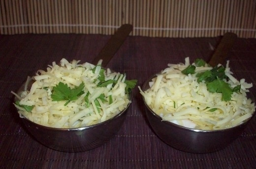 1. Этап. Жюльен из кальмаров с грибами: В сковороде на сливочном масле обжарьте муку. Добавьте в неё сметану. Перемешайте. Полученный соус разложите по формочкам поверх кальмаров. И засыпьте тёртым на крупной тёрке сыром. Добавьте зелени.