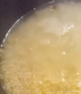 1. Этап. Рис с крабовым мясом и кукурузой: В тот же казан добавить рис и жарить, постоянно его перемешивая, в течение 3-4 минут. Добавить вино и усилить огонь. Жарить до испарения вина. Это займет около минуты. Добавить бульон и на среднем огне, постоянно помешивая, готовить 10-12 минут.