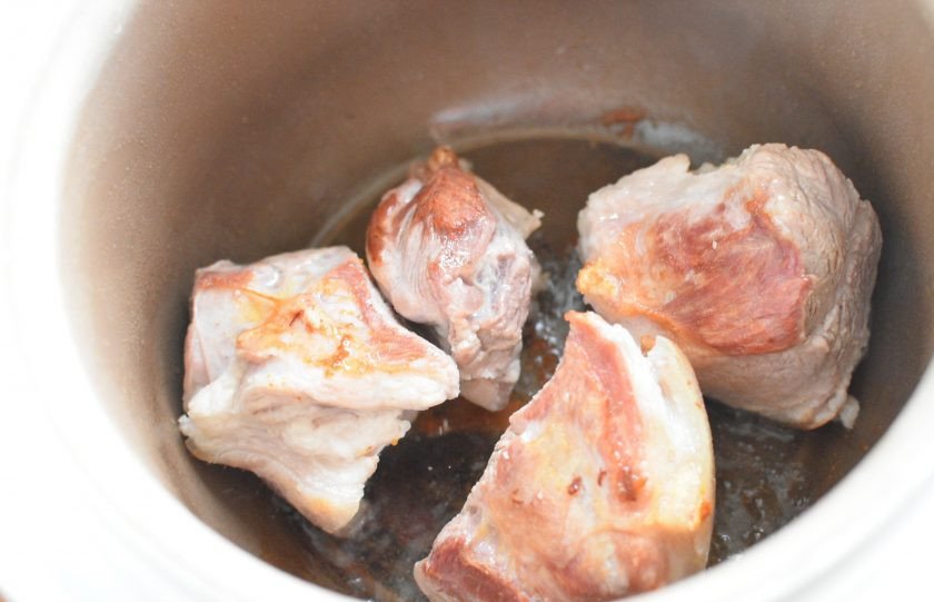 1. Этап. Свинина с перловкой по-домашнему: Мясо берите с жиром и шкуркой, которую нужно хорошо выскрести. Нарубите мясо на крупные куски, если у вас мясо с костями. У меня в этот раз задняя рулька без кости. Обжарьте мясо со всех сторон, начав с мясной стороны, до хорошей румяной корочки. Ближе к концу обжарки добавьте одну нарезанную луковицу и обжарьте ее с мясом. Затем залейте мясо кипятком вровень с мясом, посолите и поперчите по вкусу, и переключите мультиварку на режим 