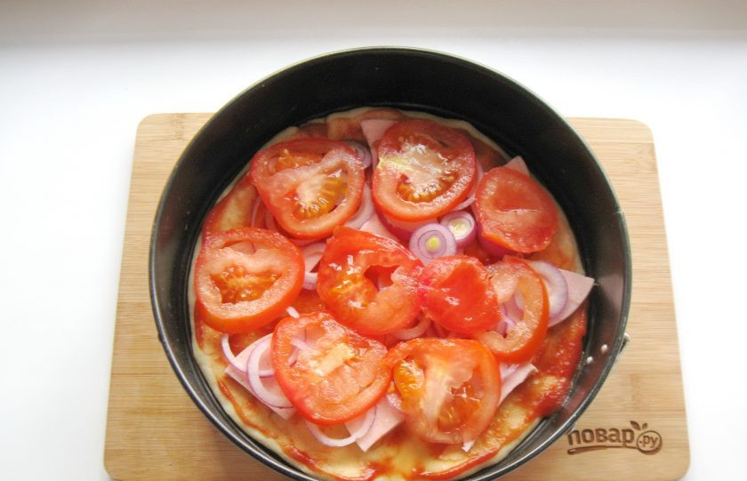 1. Этап. Самая вкусная пицца: Крупный помидор помойте и нарежьте кружками. Выложите на лук.