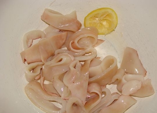 1. Этап. Кальмары в панировочных сухарях: Отварите филе кальмаров, снимите с них кожицу. После того как они остынут, нарежьте колечками.