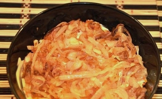 1. Этап. Салат из минтая: На морковь выкладываем слой смеси из майонеза и сметаны, затем обжаренный лук.