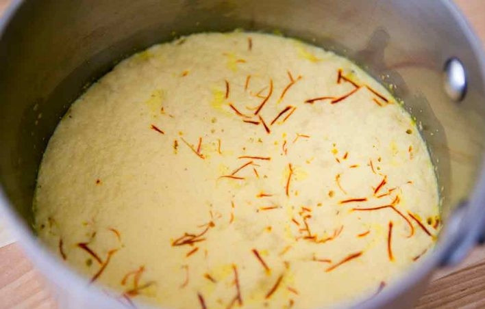 1. Этап. Булочки с шафраном: 2. Поставьте сотейник на огонь и нагрейте молоко, но не доводите его до кипения. Добавьте в молоко дрожжи и оставьте на 5-7 минут.