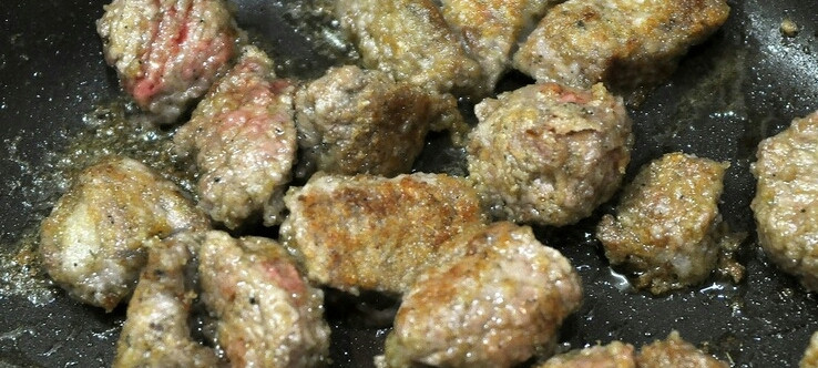 1. Этап. Говядина в чугунке в духовке: К муке добавьте специи и хорошенько, так, чтобы со всех сторон, обваляйте кусочки мяса. Потом обжарьте до румяной корочки мясо в оливковом масле. Переложите его в чугунок.