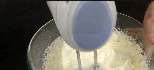 1. Этап. Простейший торт из Савоярди: В другой миске смешайте тёплое масло и сахарную пудру. Добавьте сливочный сыр и сметану, тщательно перемешайте до получения однородного крема.