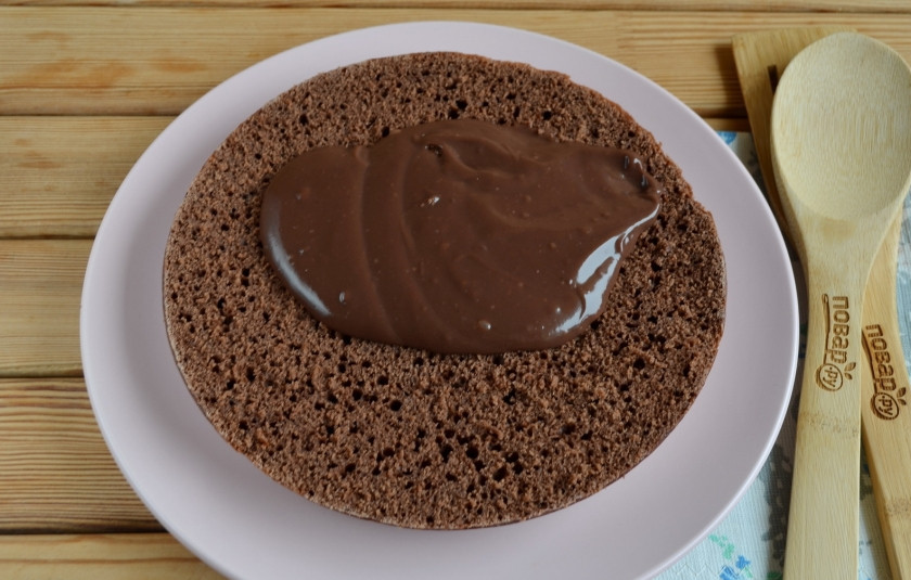 1. Этап. Быстрый шоколадный торт: Разрежьте его на две части. Обязательно пропитайте бисквит! Чем? На ваше усмотрение: можно использовать сиропы от консервированных фруктов, варенье, сахарный сироп с алкоголем. Смажьте первый корж кремом.