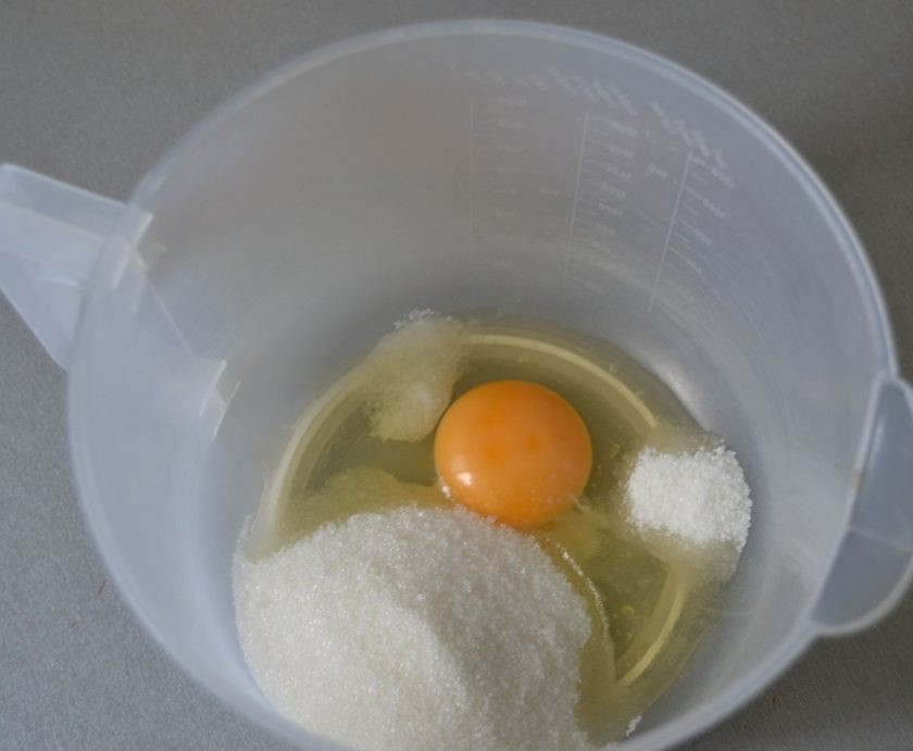 1. Этап. Лимонный торт с рикоттой: В емкость для взбивания вбейте 1 яйцо, добавьте соль, сахар (100 грамм), ванильный сахар, взбейте миксером.