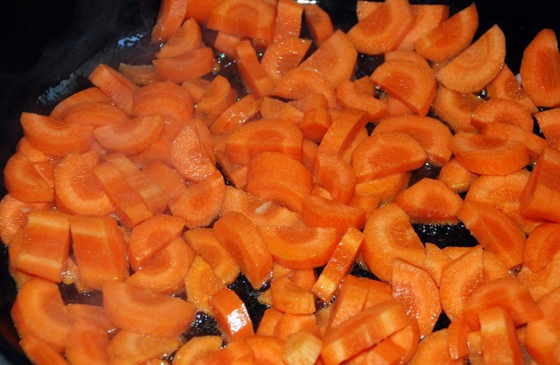 1. Этап. Жаркое по-домашнему из говядины: Пока тушится мясо, мы чистим морковь и нарезаем ее полукольцами. Разогреваем в сковороде растительное масло и обжариваем на нем морковку до румяности, затем перекладываем ее в казан.