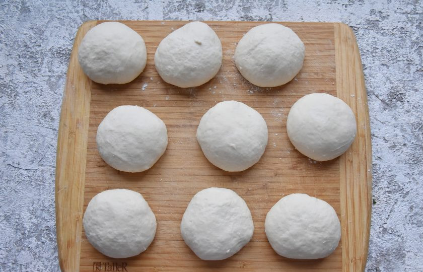 1. Этап. Лахмаджун по-турецки: Готовое тесто разделите на кусочки, весом 100-130 граммов. Каждую заготовку округлите, выложите на доску и накройте пищевой пленкой или кухонным полотенцем, чтобы тесто не подсыхало.