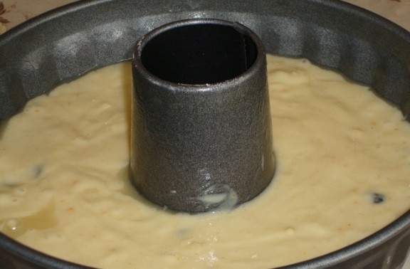 1. Этап. Кекс на кефире с изюмом: Введите в тесто яичную смесь. Форму для выпечки немного смажьте маслом и присыпьте мукой. Влейте в неё тесто.