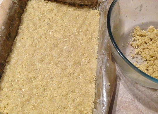 1. Этап. Шоколадная Кармелита: 5. Форму для выпечки (у меня прямоугольная 20 на 30 см) застилаем пергаментом, смазанным сливочным маслом. Выкладываем 2/3 крошки и утрамбовываем ровным слоем. Отправим в разогретую до 180 градусов духовку минут на 10-15.