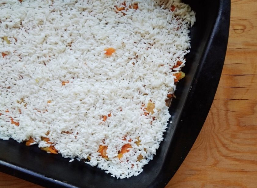 1. Этап. Куриные голени с рисом в духовке: 6. Потом промойте и разложите в форму для выпечки рис. Посолите его.