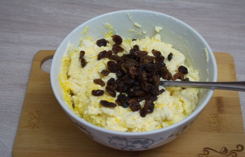 1. Этап. Запеканка из творога в духовке: В полученное тесто введите промытый изюм. Снова перемешайте, чтобы изюм равномерно распределился в тесте.