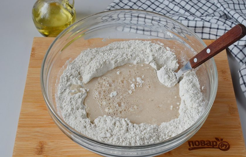 1. Этап. Простой ржаной хлеб: Сделайте в центре лунку, влейте дрожжи, начните ложкой перемешивать.