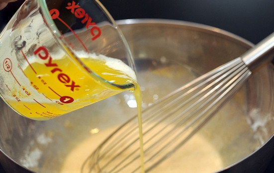 1. Этап. Пышная шарлотка: 4. В отдельной мисочке взбейте яйца с сахаром и ванильным экстрактом. Влейте растопленное сливочное масло. Всыпьте муку небольшими порциями, замешивая однородное тесто.