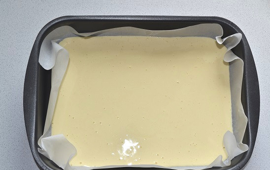 1. Этап. Рулеты с фруктовой начинкой: Жаропрочную форму застелите пергаментом. Выложите тесто, распределите ровным слоем и отправьте в духовку. На выпечку бисквита уходит около 15 минут. Готовность проверяйте зубочисткой или спичкой, она должна быть абсолютно сухой.