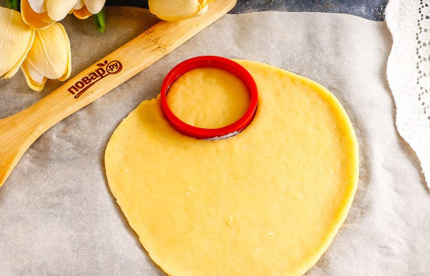 1. Этап. Сахарное печенье для росписи: Разделите его на две части и каждую из них раскатайте на пищевой пленке очень тонко. С помощью плунжера вырежьте из теста фигурки.