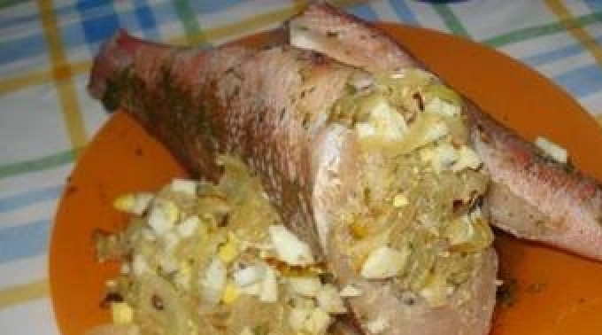 1. Этап. Жареный морской окунь: Очищаем лук. Одну луковицу мелко нарезаем и обжариваем, в это же время варим в крутую одно яйцо. Затем его мелко нарезаем, смешиваем с луком, добавляем приправ и фаршируем этой смесью рыбу.