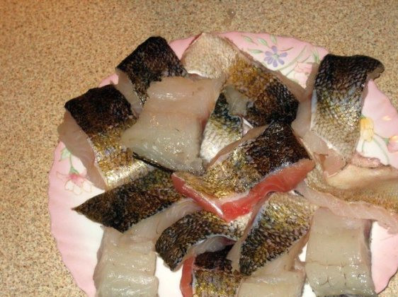 1. Этап. Сациви из рыбы: Остальную часть тушки рыбы разделываем на филе и нарезаем его на небольшие кусочки. Слегка посыпаем солью и перцем.