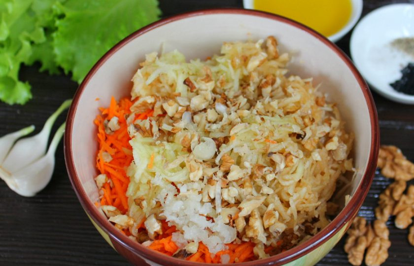 1. Этап. Салат Молодость: Далее, кладем в салат колотые орехи и пропущенный через пресс чеснок.