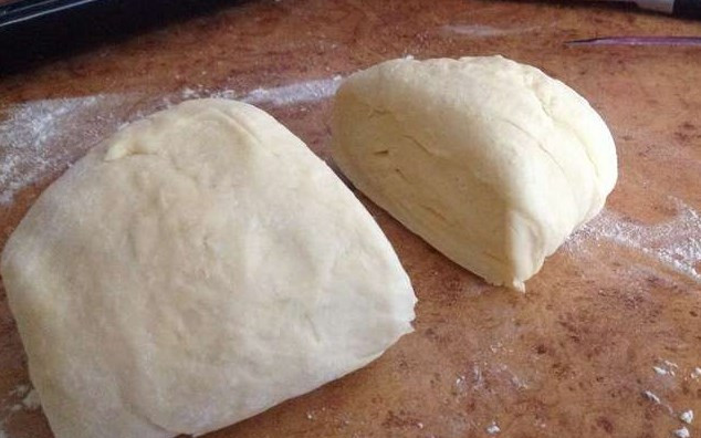 1. Этап. Хачапури из творожного теста с сыром: Тесто достаньте и разделите на две части, каждую из которых раскатайте в лепешку.