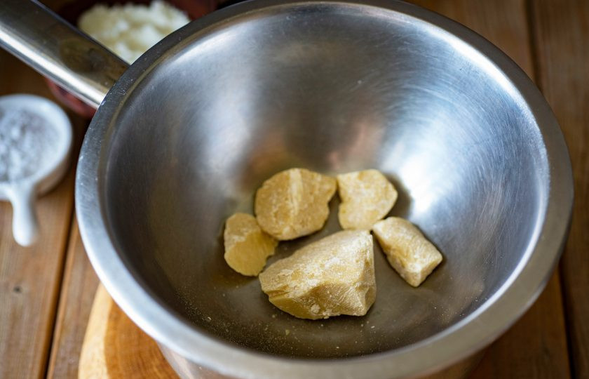 1. Этап. Белый шоколад из какао масла: В небольшую кастрюльку залейте воду и наверх установите жестяную миску так, чтобы дно не касалось поверхности воды. В миску выложите кусочки какао масла и всю эту конструкцию установите на небольшой огонь — это водяная баня.