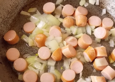 1. Этап. Картошка с сосисками в горшочках: 4. Разогрейте еще немного масла, обжарьте в нём нарезанный кубиками лук и сосиски (пару минут на среднем огне).