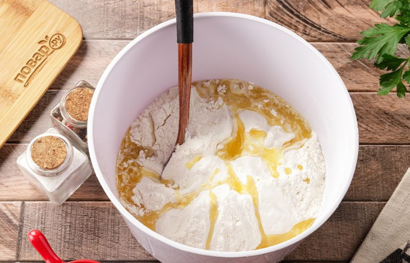 1. Этап. Жаркое в горшочке из теста: Соедините тёплую воду и соль. Добавьте около 300 грамм муки и растопленное сливочное масло. Перемешайте, а затем частями добавьте оставшуюся муку. Муки может уйти чуть больше, или меньше чем указано в рецепте.