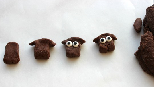 1. Этап. Кексы Овечка: Шоколадное печенье измельчаем и перемешиваем в миксере с яйцами и растительным маслом, получится однородная густая масса. Лепим из нее голову для овечки. В качестве глаз - шоколадные конфетки.