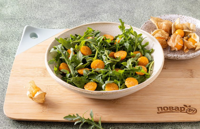 1. Этап. Салат с физалисом и руколой: Физалис очистите от чашелистика, затем тщательно промойте в теплой воде от воскового налета. Разрежьте плоды физалиса пополам и выложите в тарелку.