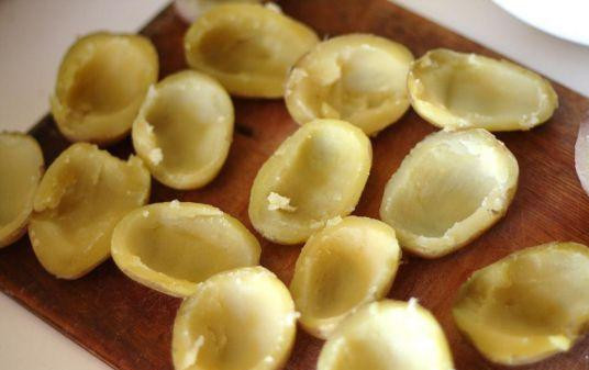 1. Этап. Запеченный картофель с начинкой: Картофель примерно одного размера следует отварить в мундире. Варить около 20 минут. затем следует его слегка остудить, разрезать по палам, очистить от кожуры и вытащить ложкой сердцевину.