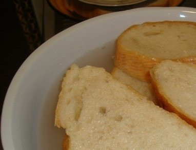 1. Этап. Котлеты из путассу: Кусочки батона положите в миску и залейте прохладной чистой питьевой водой. Вы можете использовать остатки черствого хлеба. Также подойдет сдобная булочка без начинки. Она придаст котлетам особый аромат.