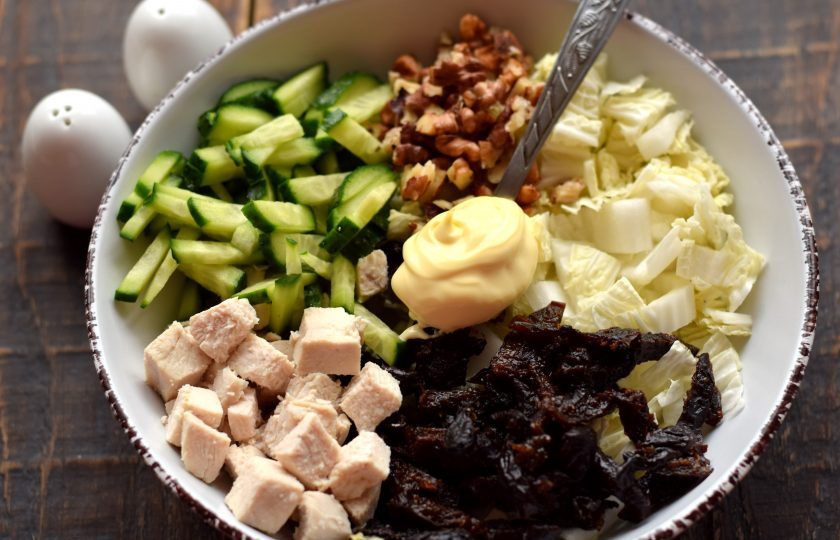 1. Этап. Салат с курицей, пекинской капустой и черносливом: Все подготовленные ингредиенты выложите в глубокую салатницу. Добавьте майонез, соль и молотый перец по вкусу.