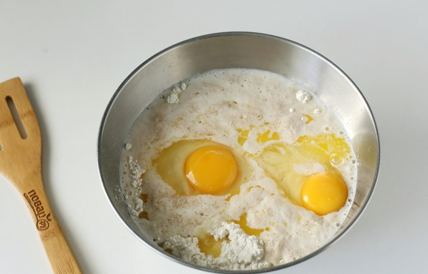 1. Этап. Булочки с курицей и сыром: В глубокую миску насыпьте 400 грамм муки, добавьте подошедшую опару, соль, яйца и растопленное сливочное масло.