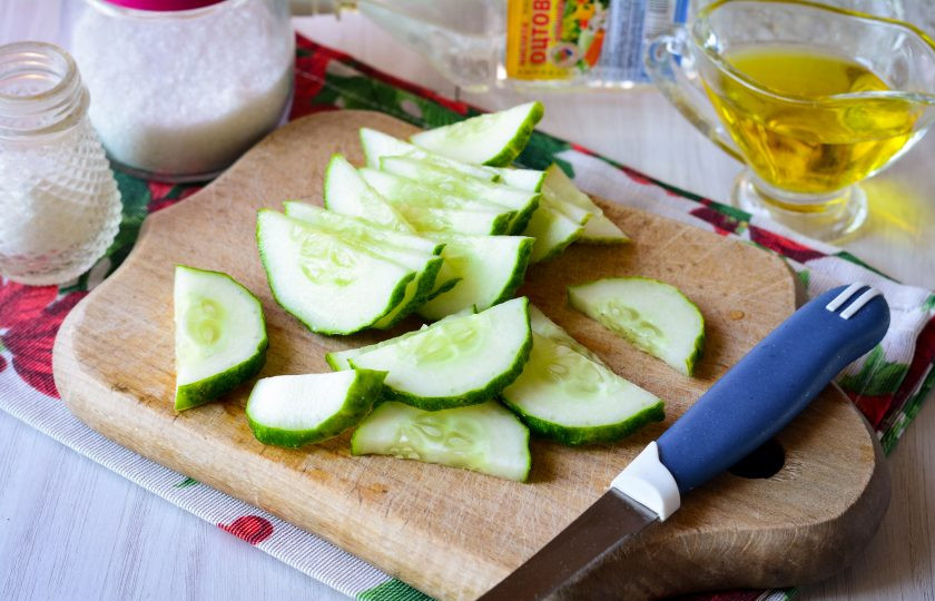 1. Этап. Салат из огурцов с перцем и луком на зиму: Вымойте огурцы, срежьте хвостики и нарежьте полукольцами для салата.