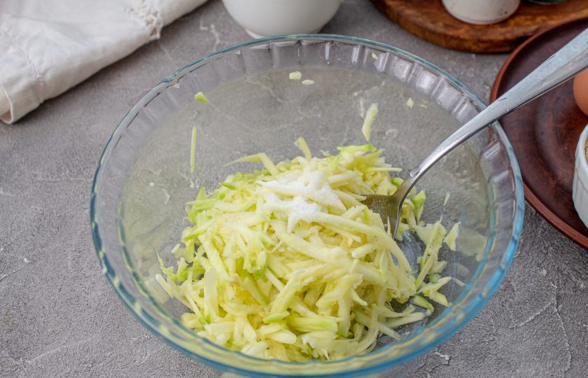 1. Этап. Кето-вафли из кабачков: Кабачок помойте и обсушите. На крупной тёрке натрите кабачок в глубокую миску. Посолите и отложите на 5-10 минут, пока кабачок не пустит сок.