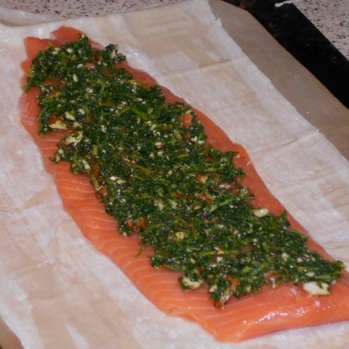 1. Этап. Простой пирог с красной рыбой: На противень выкладываем бумагу для выпечки, на нее - раскатанное тесто (у меня слоеное, но можно использовать и другое). По центру теста выкладываем кусок филе красной рыбы (без костей, чешуи и т.д.). Смазываем тесто оливковым маслом, по рыбе равномерно распределяем измельченную зеленую массу из первого шага.