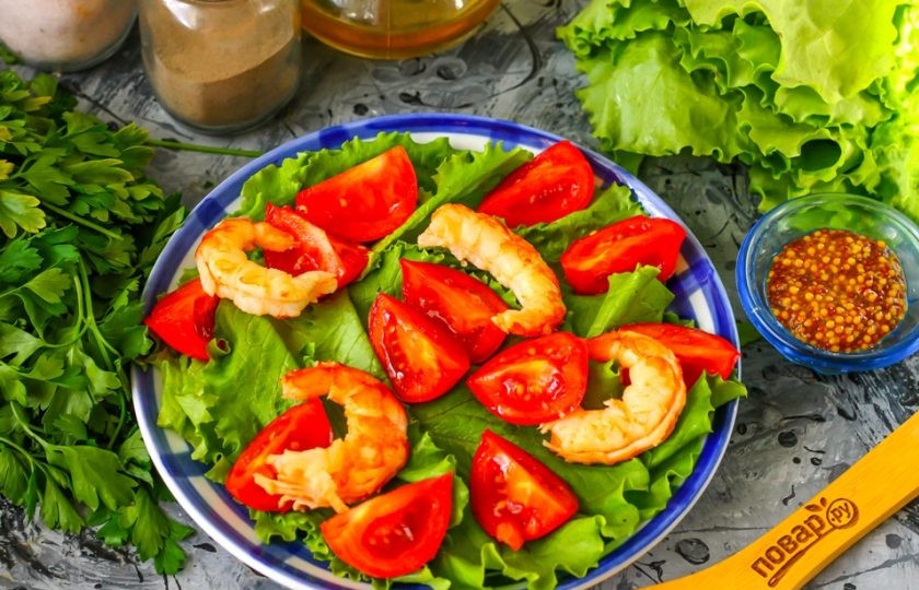 1. Этап. Легкий салат с креветками: Очищенные вареные или жаренные креветки любого сорта выложите между ломтиков томатной нарезки. Можно просто предварительно залить замороженные креветки кипятком, если они продавались вареноморожеными.