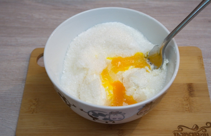 1. Этап. Запеканка из творога в духовке: Для приготовления запеканки из творога в духовке нам необходимо взять творог. Поместите его в миску. Добавьте яйца, сахар, отдушку, разрыхлитель, манную крупу.