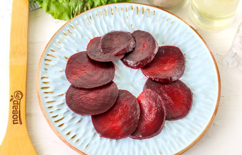 1. Этап. Карпаччо из свеклы: Очистите отварную свеклу от кожуры, промойте в воде и нарежьте тонкими круглыми слайсами. Выложите их на тарелку в виде круга. По желанию сначала можно выложить промытый листовой салат, если он имеется у вас в наличии.