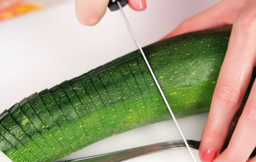 1. Этап. Запеченный цукини с пармезаном: 1. Для начала аккуратно разрежьте цукини на тонкие пластинки, не дорезая до конца. Можете подложить ложку, как на фото, чтобы было легче контролировать глубину надрезов.