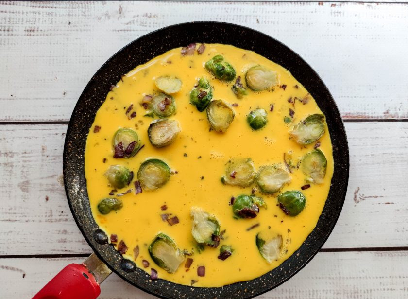 1. Этап. Омлет с брюссельской капустой: В сковороду вылейте яично-молочную смесь и готовьте омлет на слабом огне 5-7 минут под закрытой крышкой.