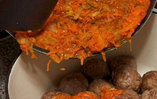 1. Этап. Подлива к тефтелям: Возьмите чугунную посуду и положите несколько горошин черного перца и 2-3 лавровых листа. Приготовленные и обжаренные тефтели уложите в эту посуду. Залейте соусом тефтели, накройте кастрюлю крышкой, доведите до кипения, затем огонь уменьшите и томите тефтели в соусе около 45 минут.