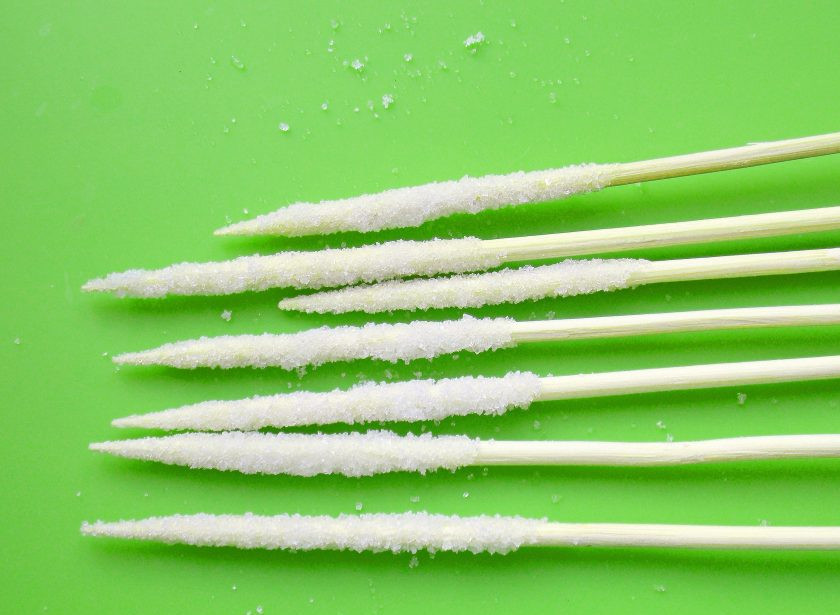 1. Этап. Сахарные кристаллы на палочке: Опустите подготовленные шпажки (у меня короткие деревянные шпажки для шашлыка) и обваляйте их в сахарном песке. Песок должен плотно и ровно распределиться на палочке. Положите заготовки на блюдо и оставьте до высыхания в течение суток.