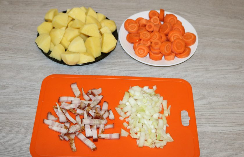 1. Этап. Коддл: Лук нарежьте кубиками, бекон соломкой. Морковь нарежьте кольцами, картофель крупными кусочками.
