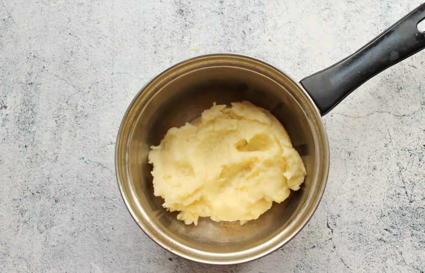 1. Этап. Пирожки Два в одном: Пока подходит тесто, подготовьте начинку. Картофель очистите и отварите в соленой воде до готовности на среднем огне. Отвар полностью слейте, а картофель помните в пюре, остудите.