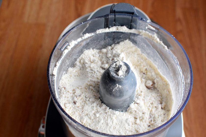 1. Этап. Песочный пирог с орехами: Для теста пробейте в комбайне орехи с сахаром до крупной крошки. Добавьте просеянную с разрыхлителем муку и щепотку соли.