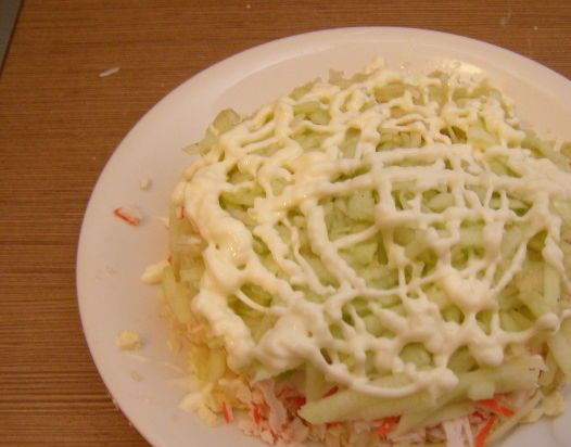 1. Этап. Крабовый салат с плавленым сыром: Выкладываем яблоки равномерным слоем, поливаем майонезом.